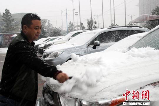 市民在清理车辆上的积雪。　于俊亮 摄